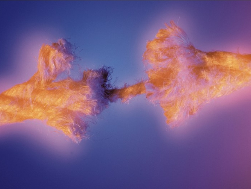 Fot eines Seils (Nahaufnahme), das nur noch an einem Strang zusammengehalten wird und kurz vor dem Zerreißen steht